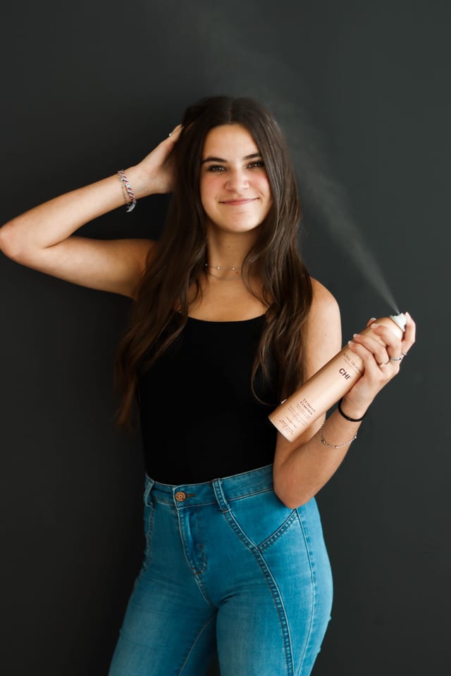 Senior applying hairspray in a styling shoot