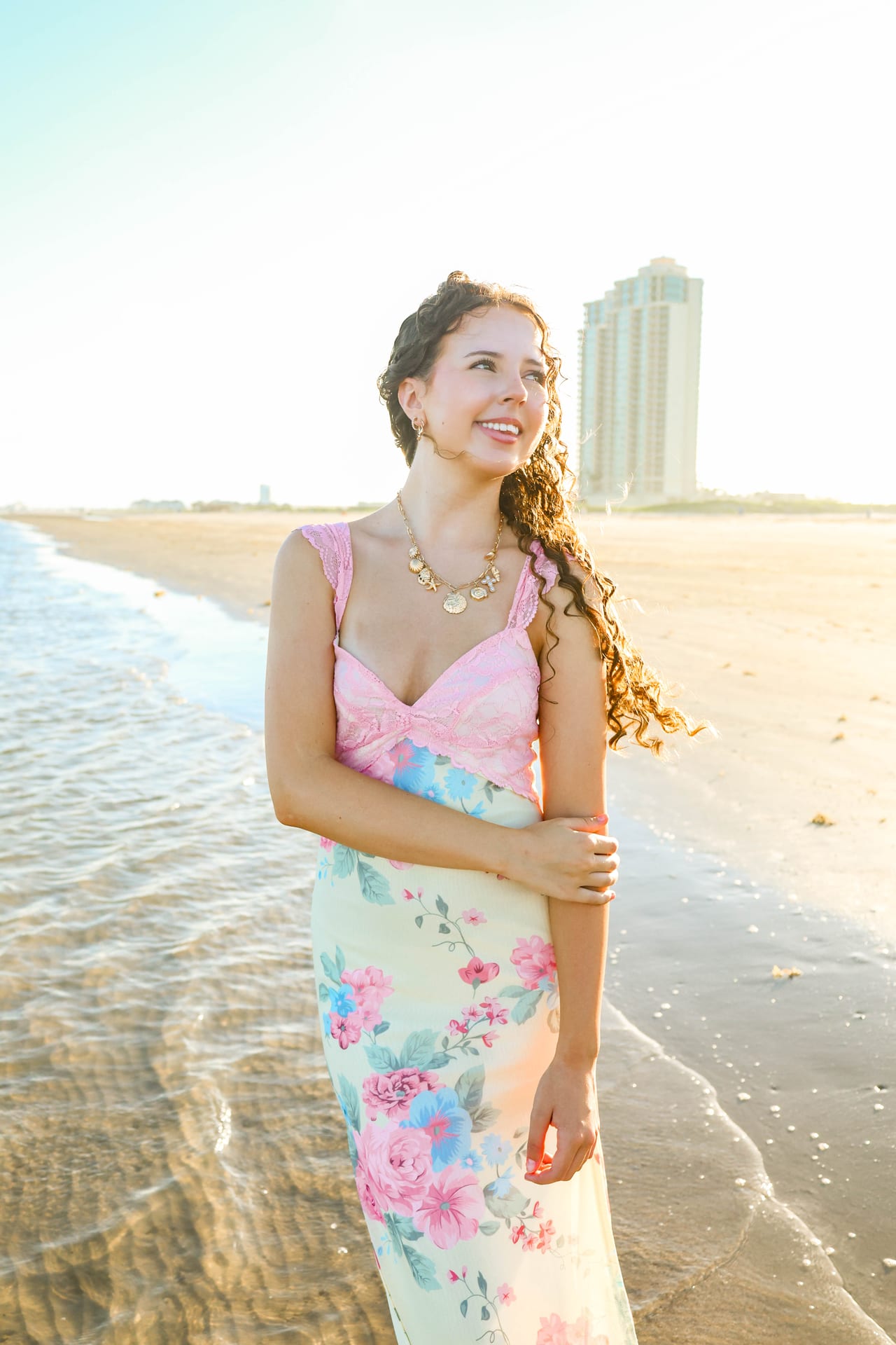 Senior in pink and floral dress at the beach
