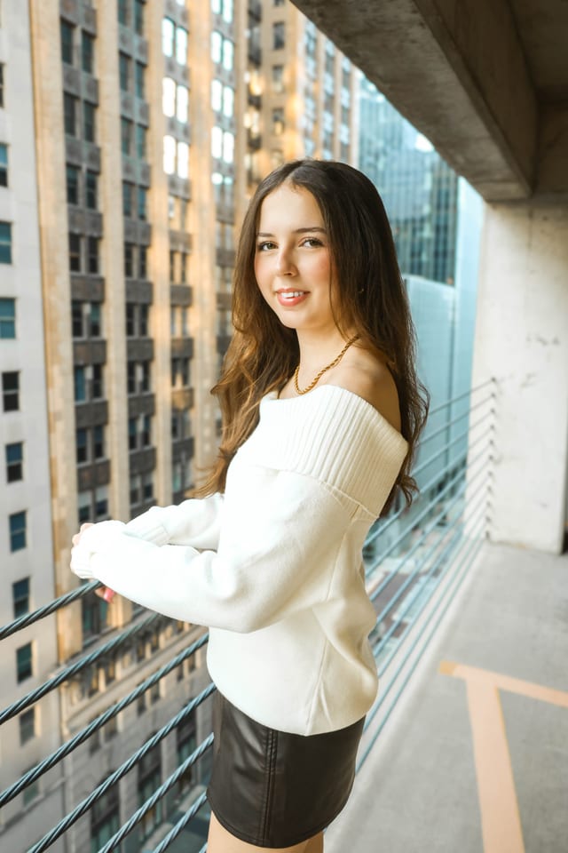 Senior in a white sweater on a downtown balcony